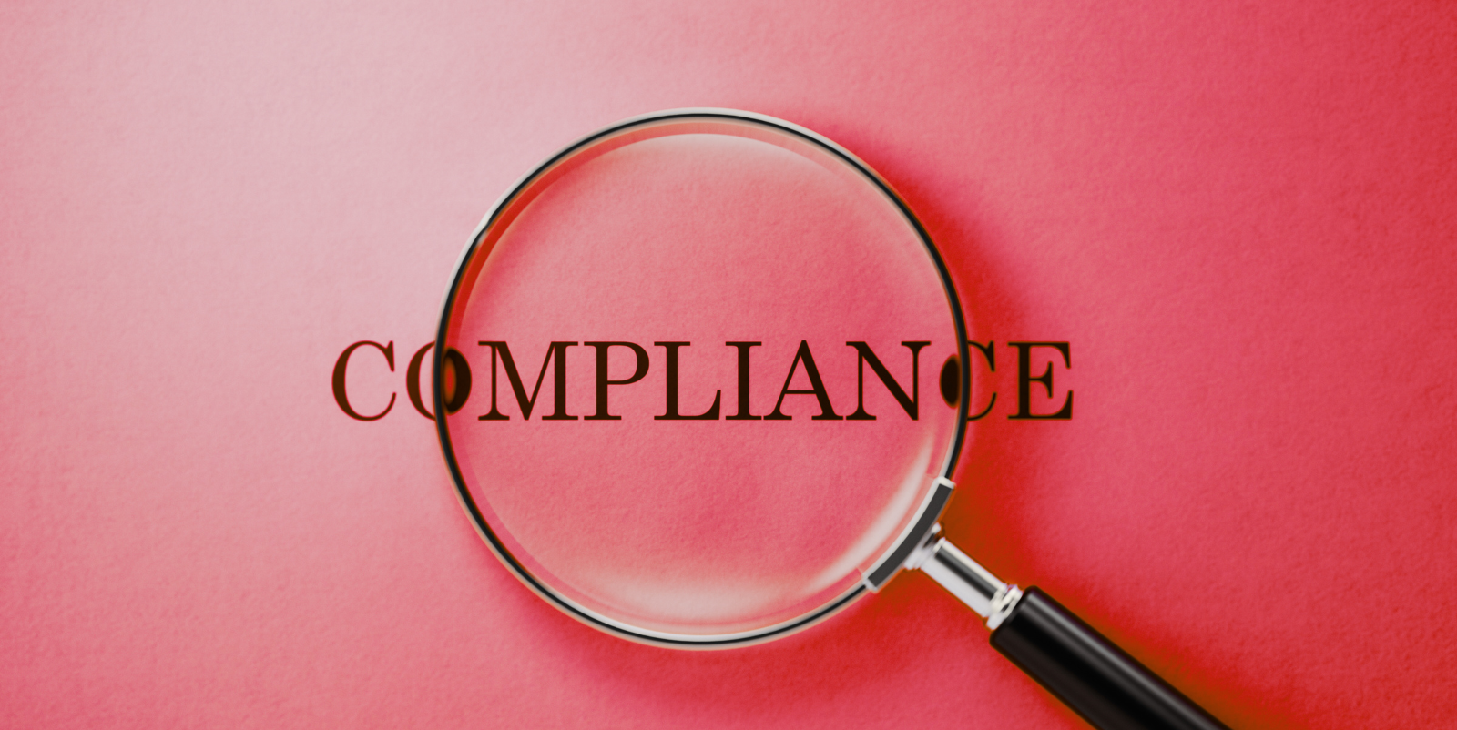 Magnifying glass over the word "compliance" set against a red background